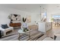 Open-concept living room and kitchen with modern decor and lots of natural light at 6971 E Lowry Blvd, Denver, CO 80230