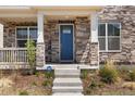 Inviting front porch featuring stone pillars and a charming blue front door at 868 N Quatar St, Aurora, CO 80018