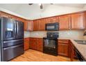 Well-lit kitchen featuring dark cabinets, stone countertops, and modern black appliances at 7732 Xavier Ct, Westminster, CO 80030