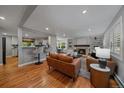 Open-concept living room with hardwood floors, a fireplace, and a view to the kitchen at 395 Zephyr St, Lakewood, CO 80226