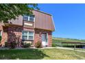 Inviting brick townhome featuring a unique roof, manicured lawn, and convenient parking at 5719 S Lowell Blvd, Littleton, CO 80123