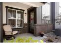 Inviting front porch with brick accents, seating, and decorative plants at 19593 W 93Rd Ln # E, Arvada, CO 80007