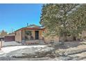 Brick ranch home with a covered porch, and snowy front yard at 2990 Sheridan Blvd, Denver, CO 80214
