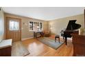 Cozy living room with hardwood floors, large windows, a piano, and comfortable seating area at 1359 Chambers Rd, Aurora, CO 80011