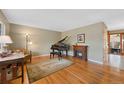 Comfortable living room featuring a piano, fireplace, and a large window providing natural light at 1359 Chambers Rd, Aurora, CO 80011