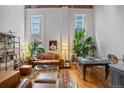 Open living room features a leather couch, area rug, plants, and large windows providing natural light at 1555 California St # 414, Denver, CO 80202