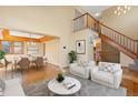 Bright living room showcasing the staircase, wood floors, and an open dining area with stylish décor at 11932 W 56Th Cir, Arvada, CO 80002