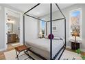 Bright bedroom featuring a four-poster bed, large windows and an ensuite bathroom at 4125 Tejon St, Denver, CO 80211