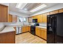 Charming kitchen with wooden cabinets, black appliances, and a bright, airy skylight at 5800 W Warren Ave, Denver, CO 80227