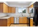 Charming kitchen featuring wooden cabinets, stainless steel dishwasher, and a window view at 5800 W Warren Ave, Denver, CO 80227