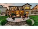 Inviting backyard patio with a stone fire pit, string lights, and comfortable seating for outdoor relaxation at 2891 Waterfront Dr, Monument, CO 80132