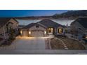 Inviting exterior of a well-maintained home featuring a three-car garage and attractive landscaping near a lake at 2891 Waterfront Dr, Monument, CO 80132