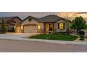 Charming single-Gathering home featuring a stone facade, well-manicured lawn, and a three-car garage at 2891 Waterfront Dr, Monument, CO 80132