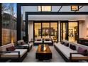Modern outdoor patio area featuring contemporary furniture, a fire pit, and sliding glass doors at 562 Steele St, Denver, CO 80206