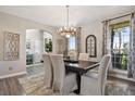 Elegant dining room with stylish chandelier, large windows, and neutral decor at 2550 Gold Creek Dr, Elizabeth, CO 80107