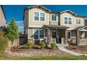Inviting two-story townhome featuring stone accents, a cozy front porch, and manicured landscaping at 2907 Distant Rock Ave, Castle Rock, CO 80109
