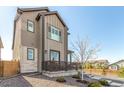 Side view of a modern home highlighting the stone accents, tidy landscaping, and a fenced yard at 10524 Eby Cir, Lone Tree, CO 80124