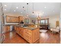 Spacious open kitchen with island and breakfast bar adjoining the living area at 6293 Ponderosa Way, Parker, CO 80134