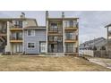 View of townhome complex featuring siding, black iron balconies and stairs to the upper units at 6009 Yarrow St # B, Arvada, CO 80004