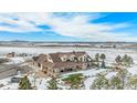 An aerial view of a ranch property with a house, shop, and snow-covered grounds at 4075 Merada Ct, Franktown, CO 80116