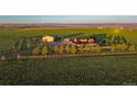 A beautiful farm with a tan house and a big green yard at 4075 Merada Ct, Franktown, CO 80116