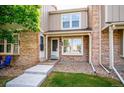 Inviting front entrance with brick facade, covered porch, and well-manicured landscaping at 9621 W Chatfield Ave # F, Littleton, CO 80128