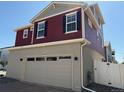 Attractive home with a two-car garage, red siding, gray stucco, and well-maintained landscaping at 22023 E 38Th Pl, Aurora, CO 80019