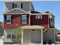 Two-story home showcasing red siding, gray stucco, dark shutters, and a cozy covered entry at 22023 E 38Th Pl, Aurora, CO 80019