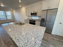 Bright kitchen with a large granite island, stainless steel appliances, and ample cabinet space at 22023 E 38Th Pl, Aurora, CO 80019