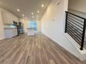 Open-concept layout with wood flooring, connecting the kitchen, living area, and staircase at 22023 E 38Th Pl, Aurora, CO 80019