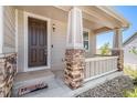 Inviting front porch with stacked stone columns and a classic wooden door at 5929 Echo Hollow St, Castle Rock, CO 80104