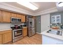 Well-lit kitchen featuring stainless steel appliances, wood cabinets, and a peninsula sink area at 4081 Odessa St, Denver, CO 80249