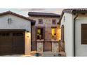 Close exterior shot of the front stone entryway with decorative railing, lamps and potted plants at 8278 Raphael Ln, Littleton, CO 80125