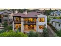 Rear exterior elevation showcasing balconies, large windows, and stone detailing at 8278 Raphael Ln, Littleton, CO 80125