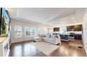 Open-concept living area with hardwood floors and bright windows, flowing into the kitchen at 10109 Yampa St, Commerce City, CO 80022