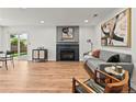 Spacious living room with hardwood floors, gray sofa, modern fireplace, and ample natural light at 3001 S Ursula Cir # 101, Aurora, CO 80014