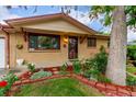 Inviting front entrance with manicured flower beds, a red brick border, and classic design elements at 1285 Elder St, Denver, CO 80221