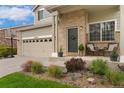 Inviting front porch with chairs, plants, and charming brickwork details at 10475 E Abilene St, Commerce City, CO 80022