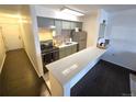 A kitchen with grey cabinets, stainless steel appliances, long counter, and wood-look floor at 1020 15Th St # 21M, Denver, CO 80202
