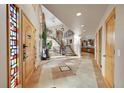 Bright foyer with tile flooring, staircase, arched doorways, and light wood accents at 14955 W 58Th Pl, Golden, CO 80403