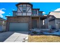 Inviting two-story home with a brick and siding facade, attached two car garage, and covered front porch at 6591 N Ceylon St, Denver, CO 80249