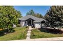 Charming one-story home featuring a landscaped front yard and classic architectural details, with lush trees surrounding the property at 5302 Pinehurst Dr, Boulder, CO 80301