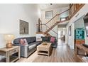 Stylish living room with wood floors, a comfortable sectional sofa, and modern staircase leading to a second story at 8170 E Phillips Cir, Centennial, CO 80112