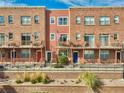Townhome exterior featuring brick facade, balconies, and a neatly landscaped front area at 7848 W 54Th Ave, Arvada, CO 80002