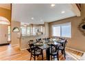 Stylish dining area with hardwood floors and adjacent, bright kitchen at 3644 Rosewalk Cir, Highlands Ranch, CO 80129