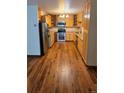 Well-lit kitchen featuring hardwood floors, stainless steel appliances, and granite countertops at 655 S Alton Way # 6A, Denver, CO 80247
