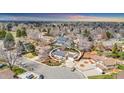 Aerial shot of a neighborhood showcasing the house with solar panels and surroundings at 7727 W 81St Pl, Arvada, CO 80005