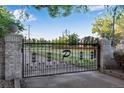 Ornate gated entrance featuring brick pillars, decorative metalwork, and a private drive at 11345 W 38Th Ave, Wheat Ridge, CO 80033