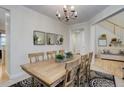 Elegant dining room featuring a wood table, classic chandelier, and seamless access to the adjacent living spaces at 12451 Turquoise Terrace Pl, Castle Pines, CO 80108