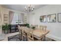 Bright dining room with a wood table, stylish rug, modern chandelier, and ample natural light at 12451 Turquoise Terrace Pl, Castle Pines, CO 80108